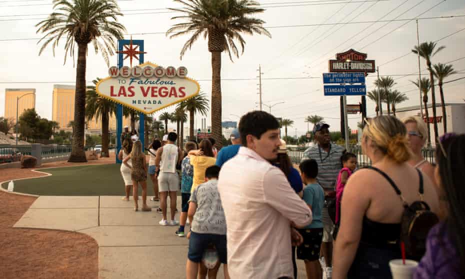 Amid a devastating heatwave, dozens of tourists wait in the oppressive temperatures to snap a selfie with the famous Las Vegas sign.