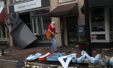 Mitch Pickering plays his guitar while walking through the downtown area after Hurricane Laura passed through on August 27, 2020 in Lake Charles, Louisiana.