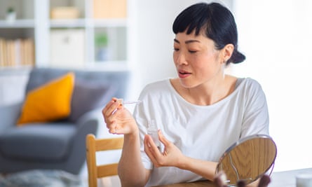 Woman using face serum for her daily skincare routine, promoting beauty and self-care