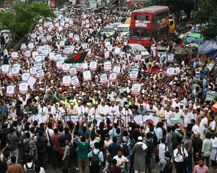 A crowd holds up placards as they are filmed by onlookers