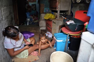 Jeny, 26, takes care of her youngest child inside her shanty in Delpan slum, Binondo district, Manila.