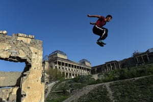 A young Afghan practises his parkour skills in the shadow of the Darul Aman palace