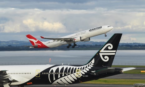 A Qantas plane takes off at Auckland airport destined for Sydney next to an Air New Zealand aircraft