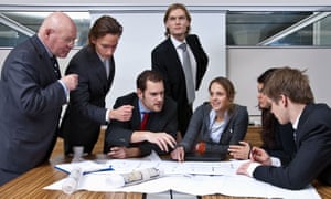 A company manager, and his team, discussing plans in a modern office