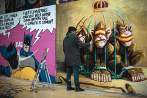 A street artist creates a mural criticising the monarchy