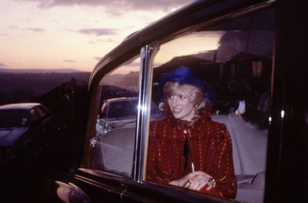 Diana in a blue hat and cherry-red fringed coast in a limousine against a sunset