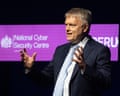 Richard Horne, NCSC CEO, speaks with a headset microphone against a purple backdrop