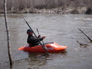 A paddler navigates through barbed wire across the Rio Chama in New Mexico.