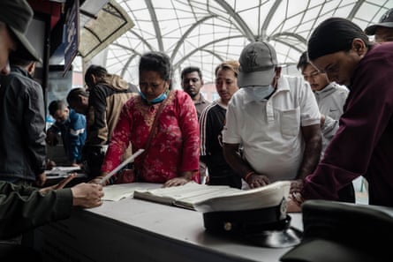 Relatives look through the lists of missing flood victims at the teaching hospital