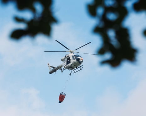 A police helicopter carries a Bambi Bucket as it prepares to drop water on to a wildfire burning in Waimes, Belgium.