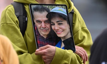 Torso of person holding tablet with picture of man and younger woman