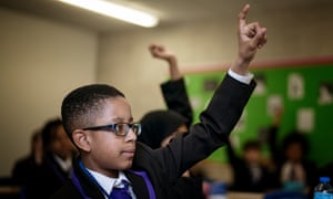 Boy in class with hand raised