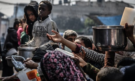 Palestinians queue for food in Rafah, Gaza, 25 February 2024.