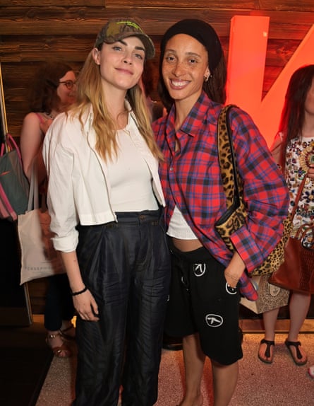 Cara Delevingne and Adwoa Aboah. Aboah is wearing a red and blue checked shirt