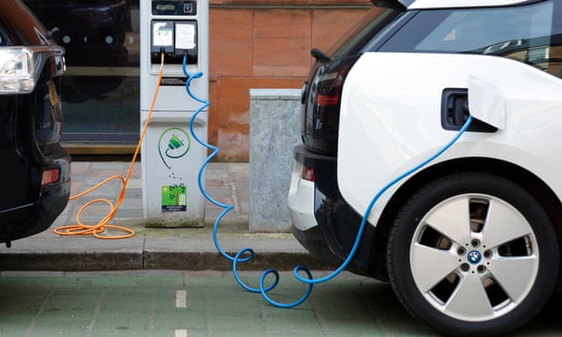 Two electric cars charging on a city street, UK.