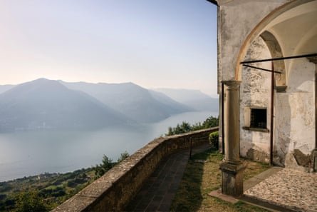 A 13th century chapel overlooks a misty hilly backdrop.