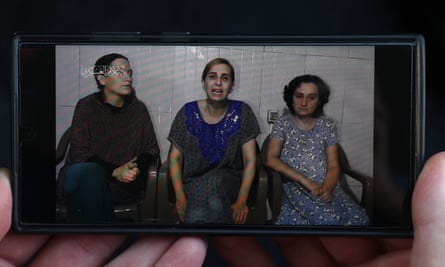 pictures in research paper A phone displays footage released by Hamas showing three hostages (left to right) Rimon Kirsht, Danielle Aloni and Elena Trupanov.