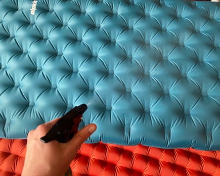 Testing a camping mattress by spraying it with water