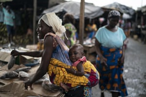 A woman carries her baby as she places fish for sale at a market in the Abobo neighbourhood. Ivory Coast’s main opposition parties boycotted the presidential election on Saturday saying at least a dozen people had died in clashes as the incumbent president, Alassane Ouattara, sought a controversial third term in office