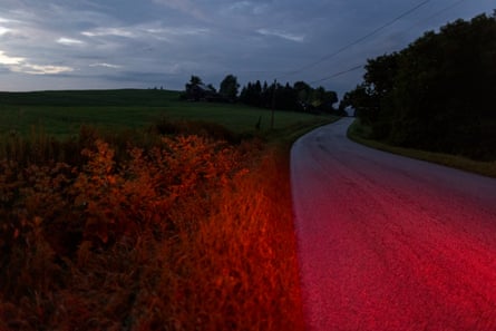 A stretch of road at dusk lit by red brake lights