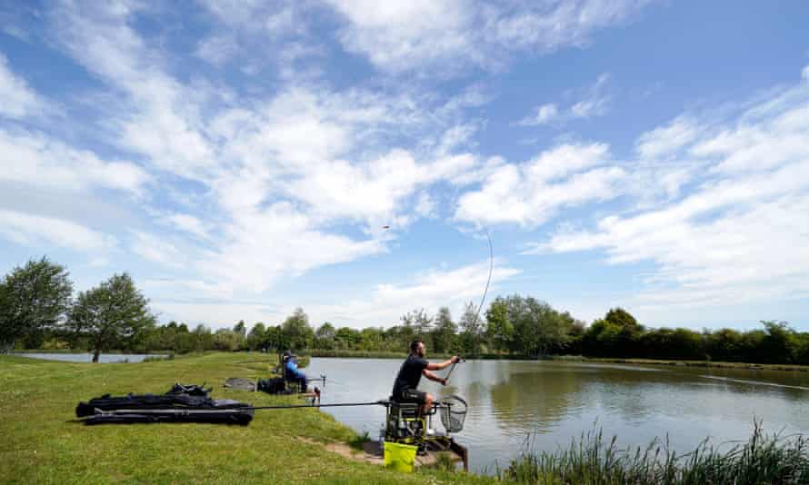 fishing by a lake under a bright blue sky