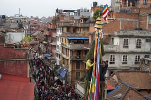 Men ride a chariot through Kathmandu during the Seto Machindranath festival
