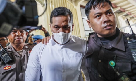 Police officer Bambang Sidik Achmadi is escorted to court before being acquitted of negligence over the deadly crowd crush last October