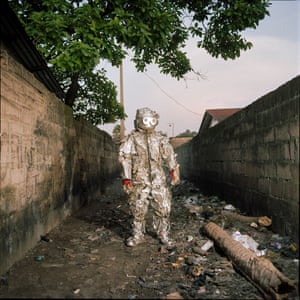Artist Junior Lohaka Tshonga posing in his spacesuit in Kinshasa. His suit is a metaphor for protection against ambient pollution in the city. A way to protect the body from toxic materials