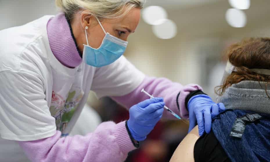 A doctor administers the Covid-19 Pfizer vaccination for local residents in London