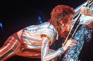 Bowie on stage biting his guitarist, Mark Ronson’s, strings in 1973