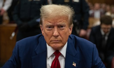 a man in a blue suit and red tie sits in court