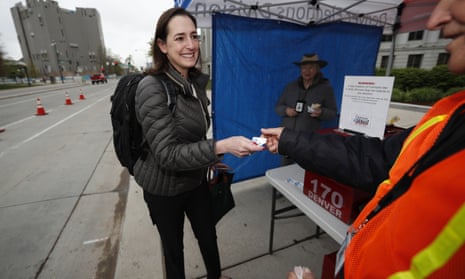 Nilufer Saltuk of Denver smiles as she gets a sticker for dropping off her ballot in Denver