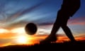 A female footballer in action as the sun sets