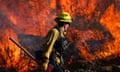 A firefighter works to extinguish a wildfire