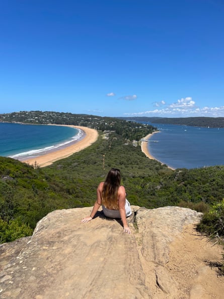 Young women leans back in front of an ocean view