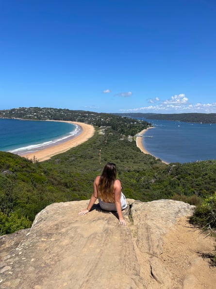 Young women leans back in front of an ocean view 