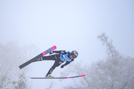 Marius Lindvik flies through the air during a ski jump.
