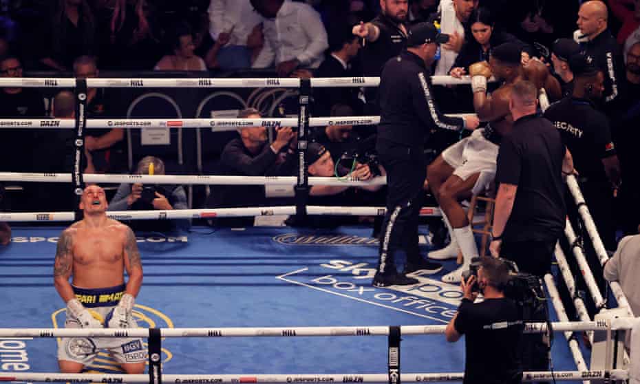 Oleksandr Usyk celebrates just after the final bell as Anthony Joshua sits in his corner