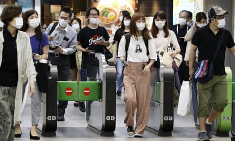 Rail passengers at Yokohama station. People in Japan began to wear masks back in February.