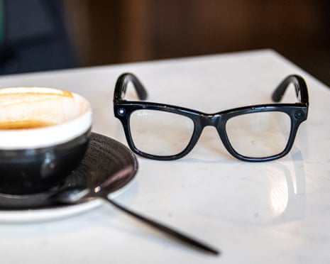 A pair of Meta smartglasses on a table next to a half-drunk cup of coffee