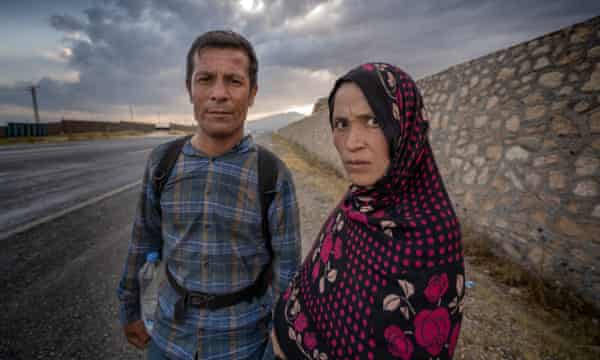 An Afghan couple walk under the summer sun on the the Erciş-Bitlis highway. The woman is pregnant.