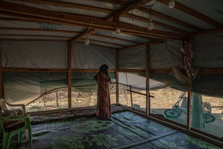 Mariam, 49, in her tent where she lives with eight other people, including her three children