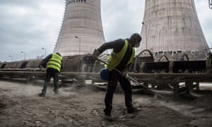 Two PPC workers clean the ash around the conveyor belt which transfers the coal.