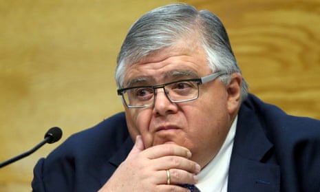 Agustín Carstens in front of a microphone, wearing a blue suit