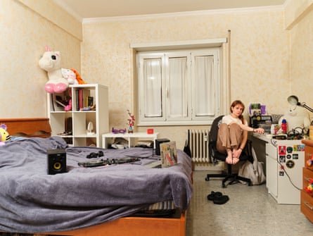 Silvia at a desk in her room - a large stuffed unicorn sits on top of a bookcase