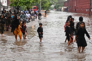 Residents wade through a flooded street