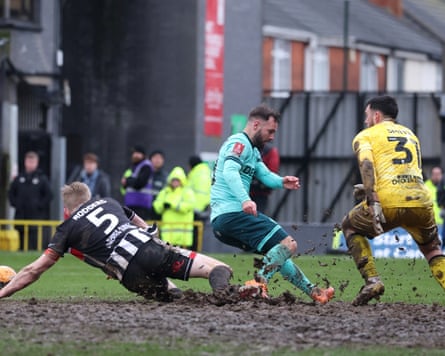 Wolves’ Adam Armstrong is tackled in atrocious conditions at Blundell Park