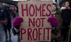 A protestor holds a placard reading 'Homes not profit'