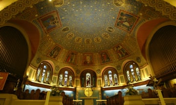 The interior of a church shows the artwork on the ceiling and stained glass windows