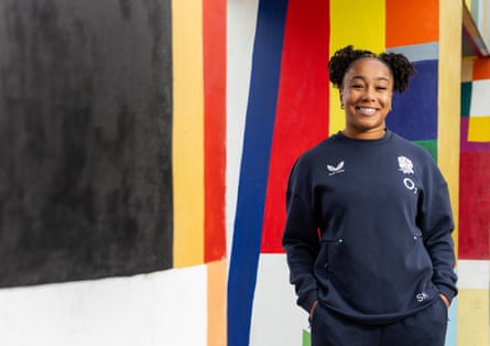 Sadia Kabeya stands in front of a brightly coloured wall at Loughborough University.